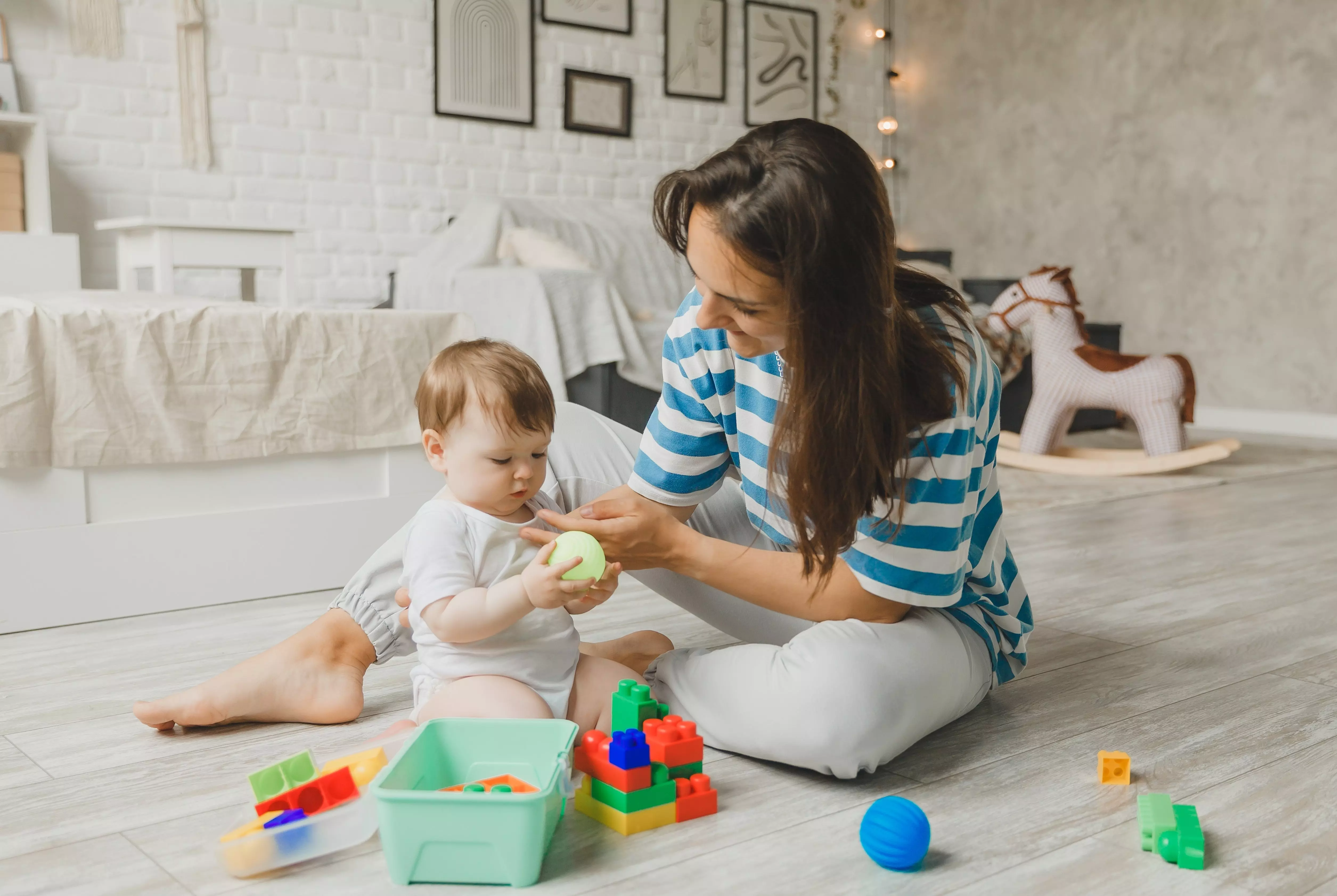 Pepco mother and baby playing with colourful building blocks together on the floor in a bright living room.
