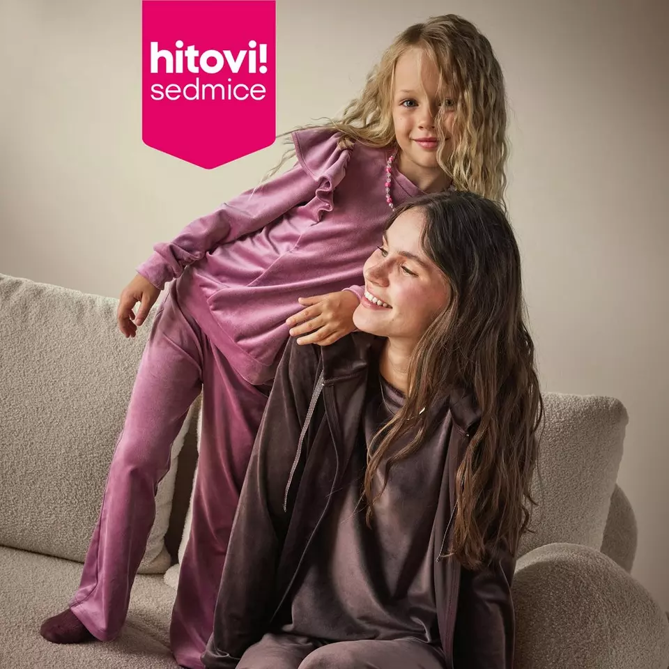 Pepco girl in pink satin outfit sitting on woman wearing brown satin loungewear on sofa.