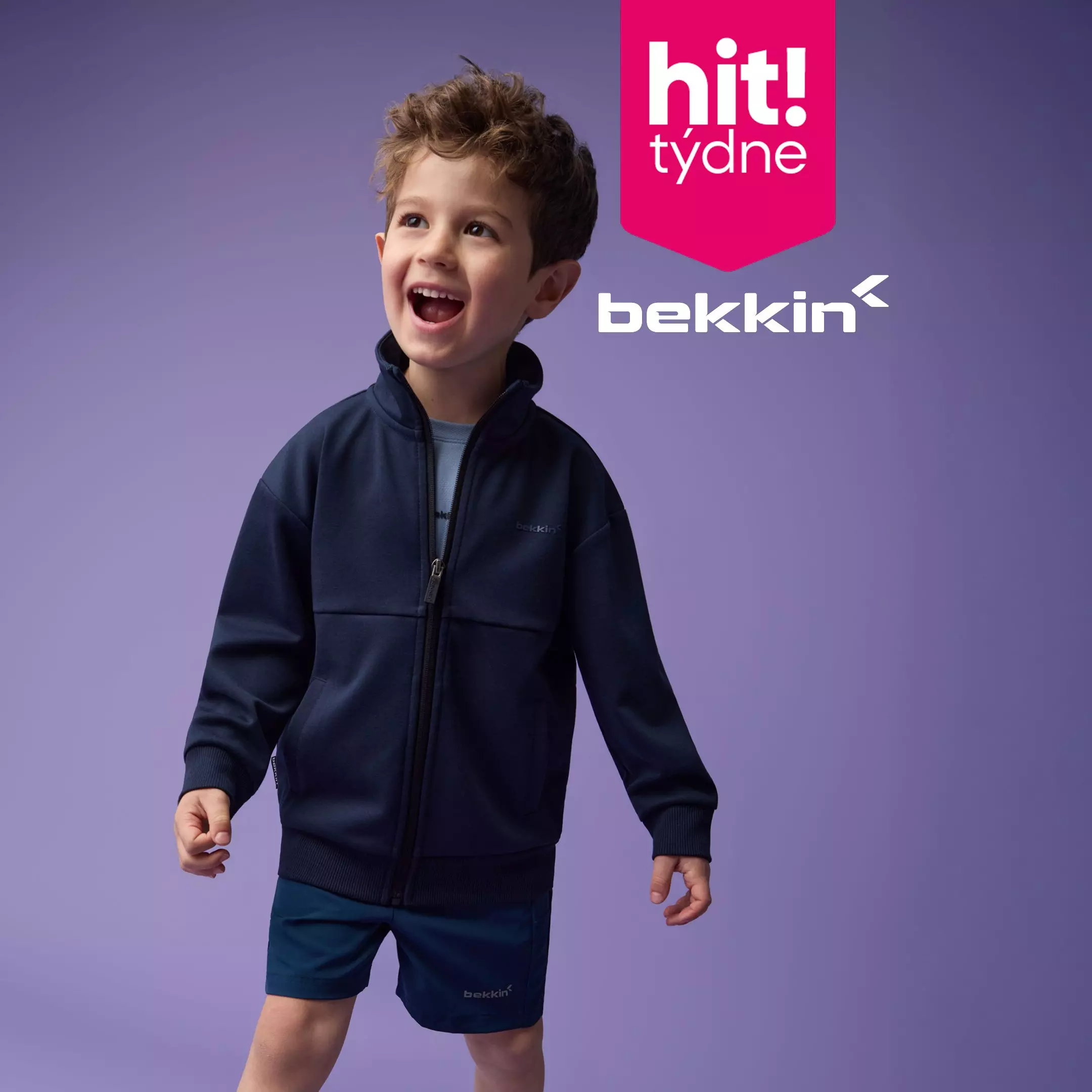 Chlapec v tmavě modré mikině a kraťasech značky bekkin od Pepco s nápisem hit! týdne.