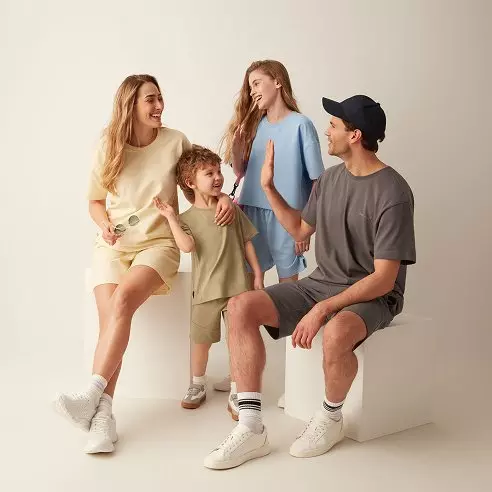 Šťastná rodina ve volnočasovém oblečení, rodiče s dvěma dětmi v pastelových tónech.