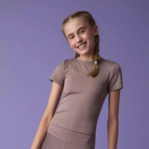 Niña sonriente con coleta lleva camiseta deportiva marrón de manga corta de Pepco.