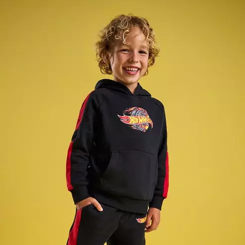 Chlapec v čiernej mikine Pepco s kapucňou a logom Hot Wheels s červenými pruhmi po bokoch.