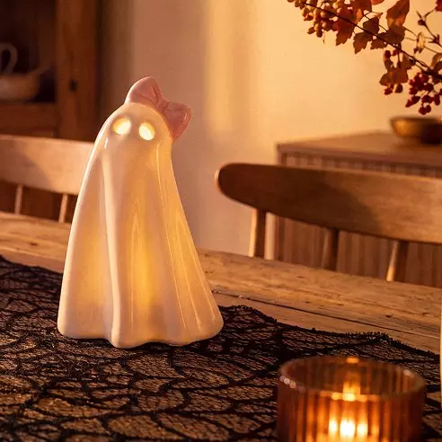 Pepco svietiaca halloweenska dekorácia v tvare ducha s ružovou mašľou na jesennom stole.