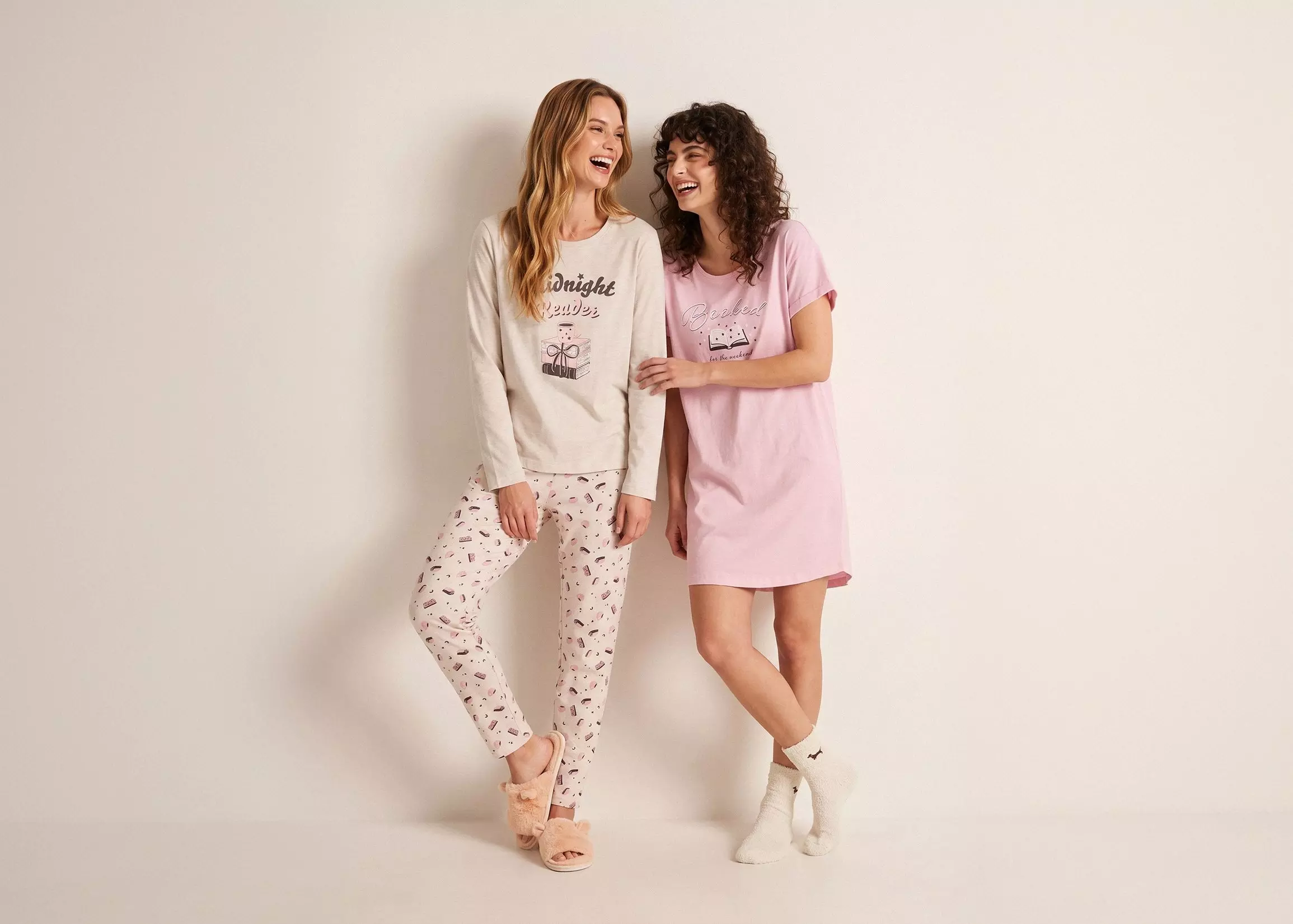 Dos mujeres riendo con pijamas Pepco: camiseta y pantalón estampado y camisón rosa con texto.