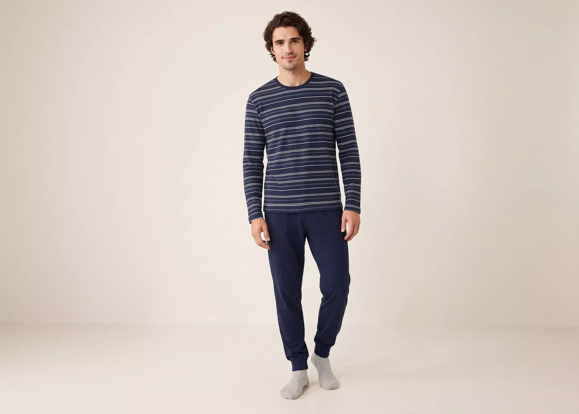 Hombre con pijama Pepco de camiseta azul marino con rayas blancas y pantalón azul marino.