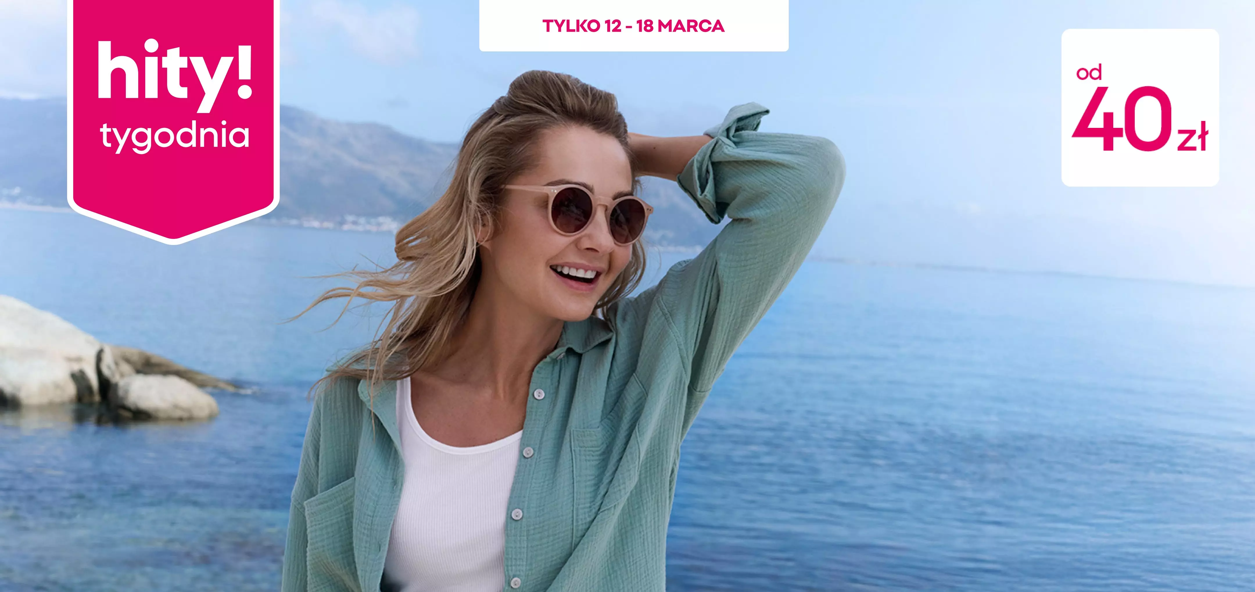 Kobieta w okularach słonecznych i miętowej koszuli uśmiecha się nad brzegiem morza.