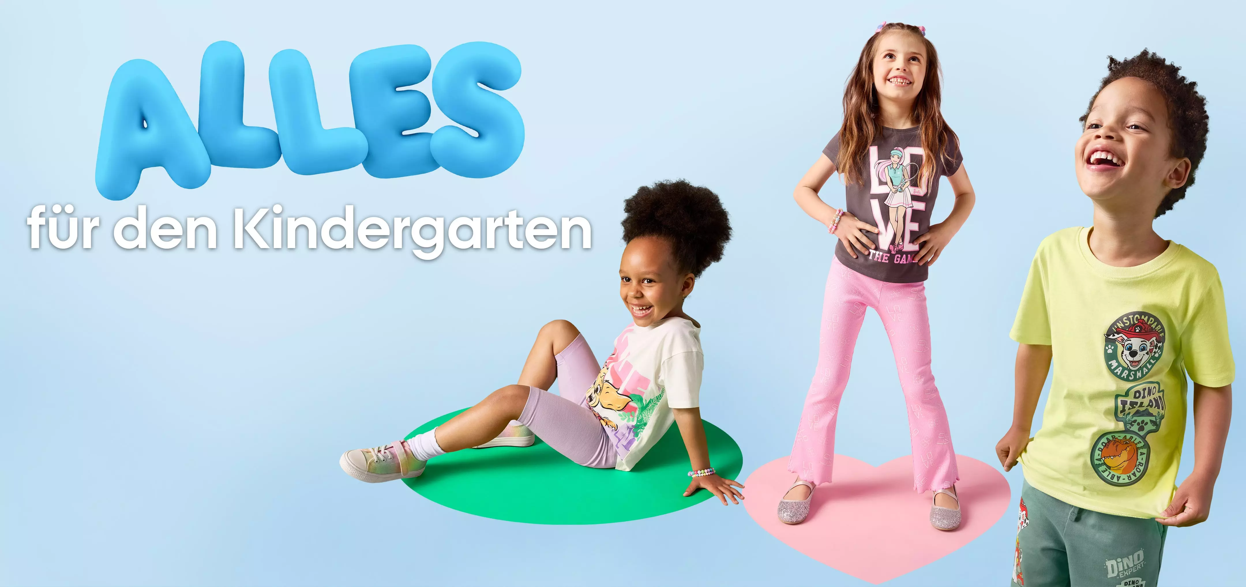 Drei fröhliche Kinder in bunter Pepco Freizeitkleidung für den Kindergarten.