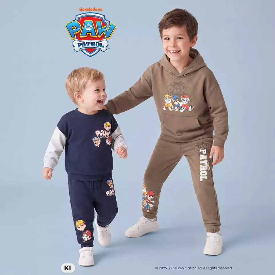 Pepco PAW PATROL Kinderkleidung: Zwei Jungen in bunten Jogginganzügen mit Charaktermotiven spielen fröhlich.