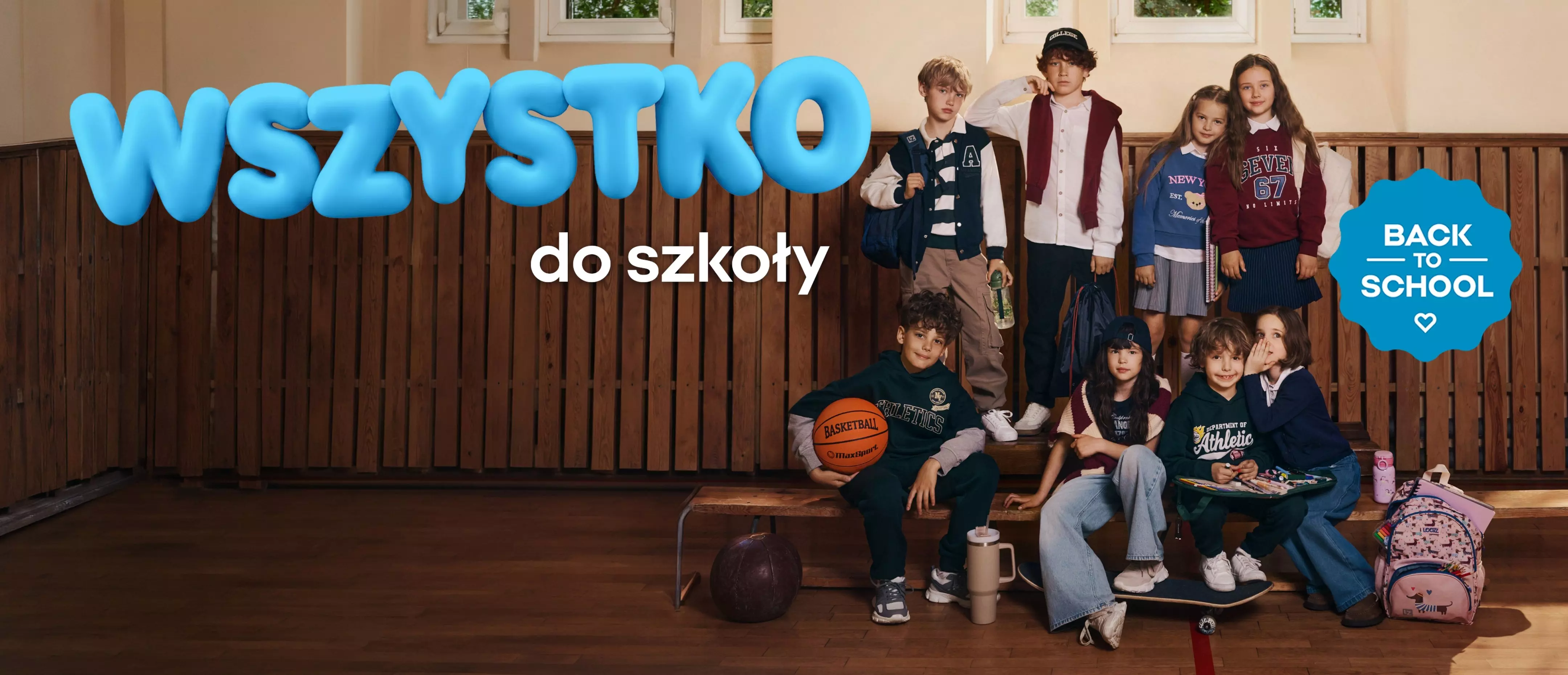 Dzieci w szkolnych strojach Pepco z plecakami i artykułami sportowymi, napis WSZYSTKO do szkoły BACK TO SCHOOL.
