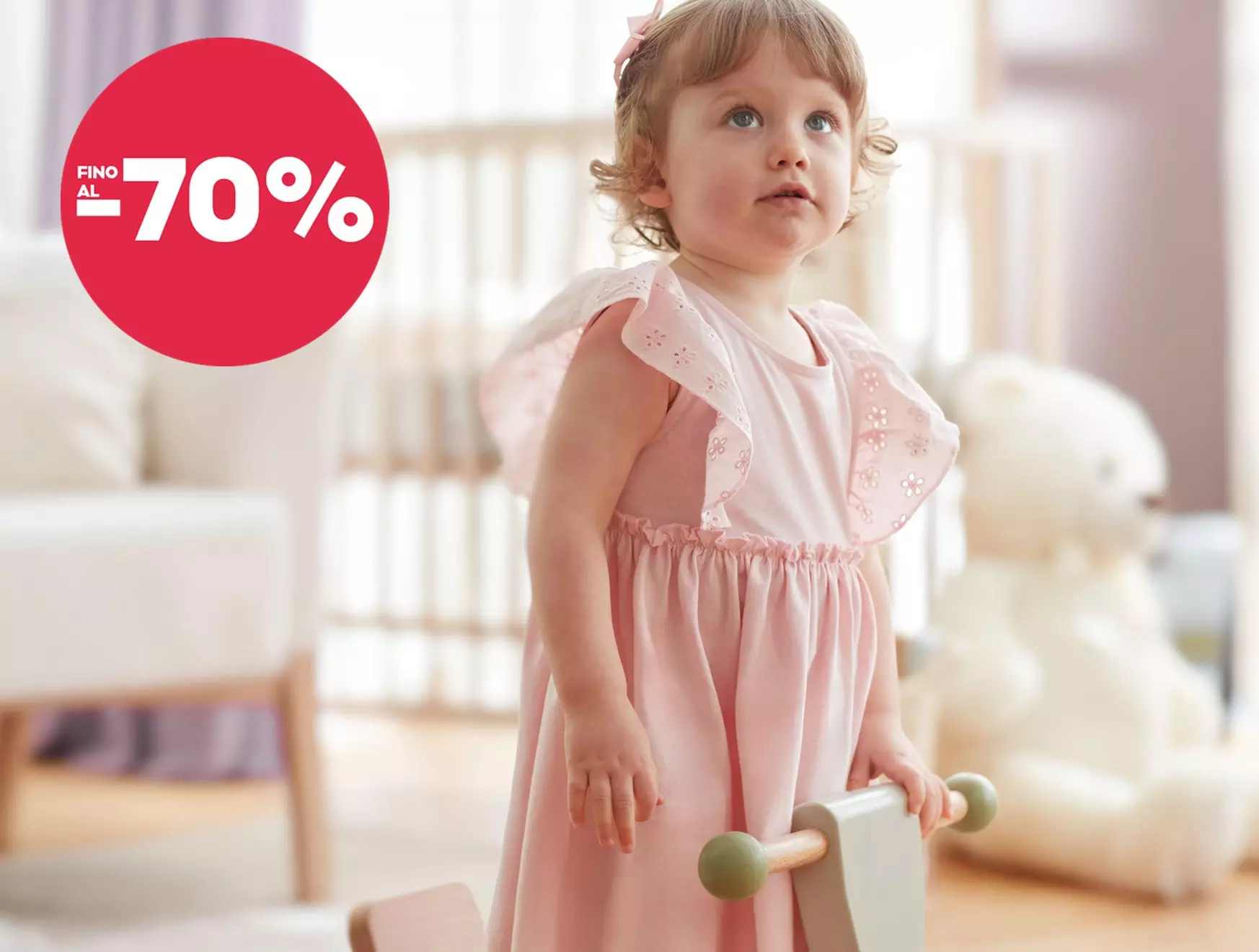 Bambina Pepco indossa un vestito rosa con dettagli floreali, sconti fino al -70%.