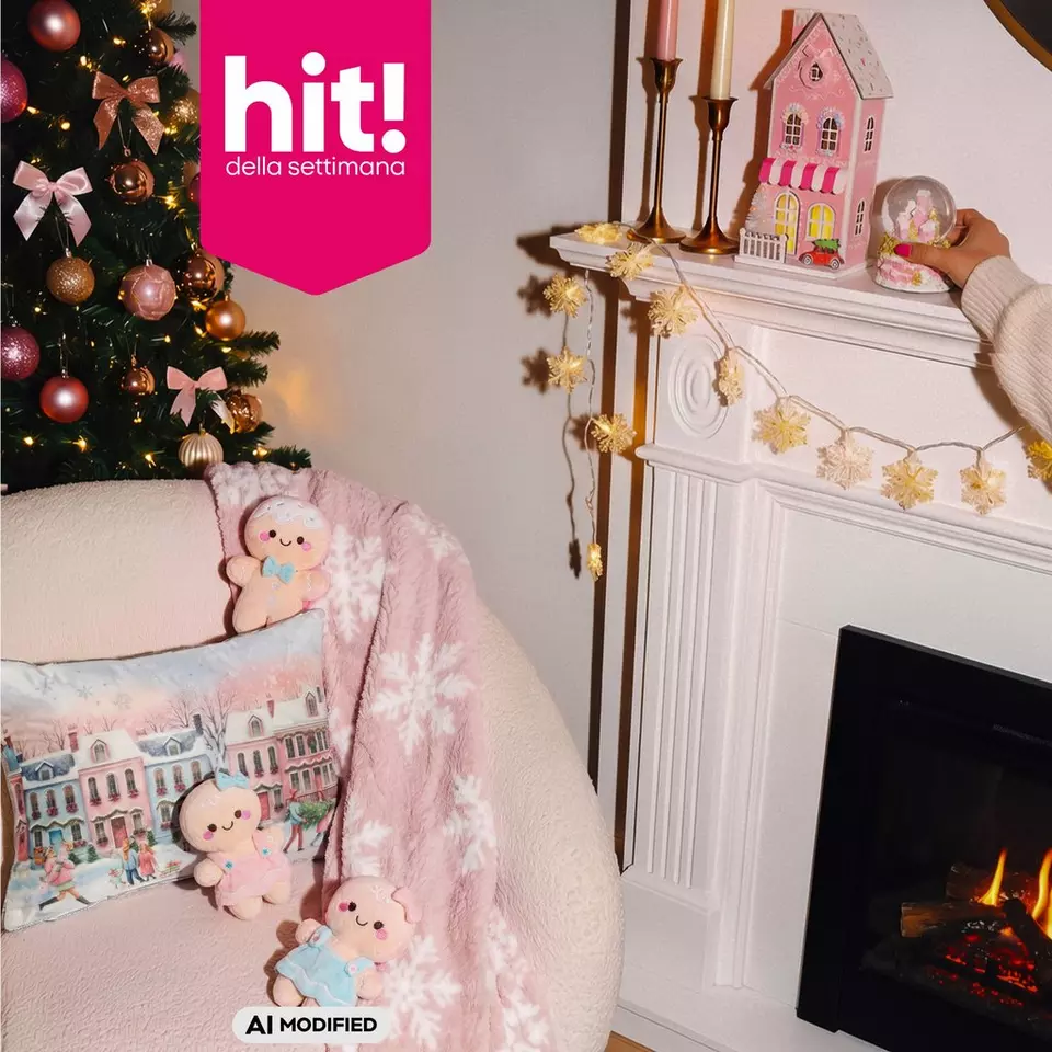 Decorazioni natalizie Pepco con albero addobbato, camino con casetta rosa e cuscini con pupazzi di pan di zenzero.