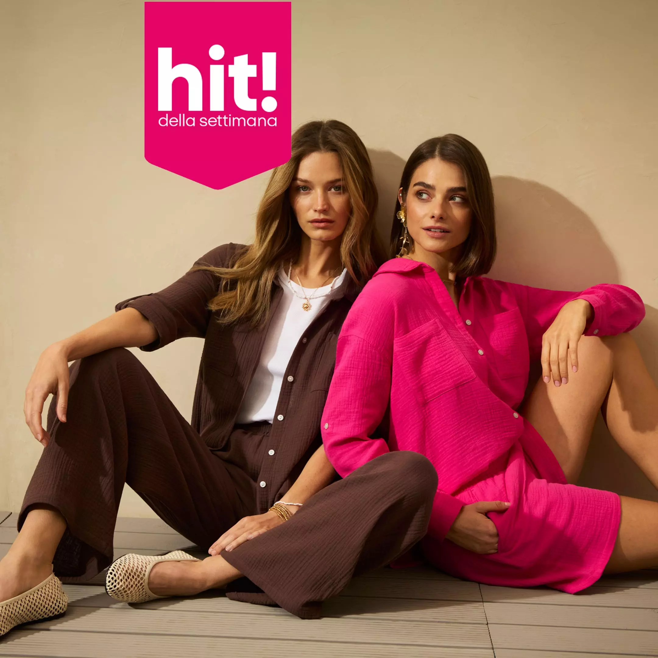 Due modelle Pepco sedute indossano completi marrone e fucsia per la promozione hit! della settimana.