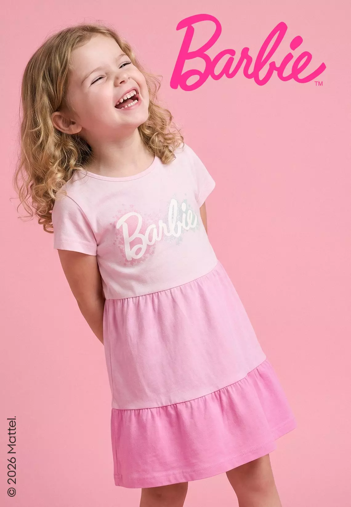 Niña sonriente vistiendo vestido rosa de Barbie de Pepco con diseño de volantes en capas.