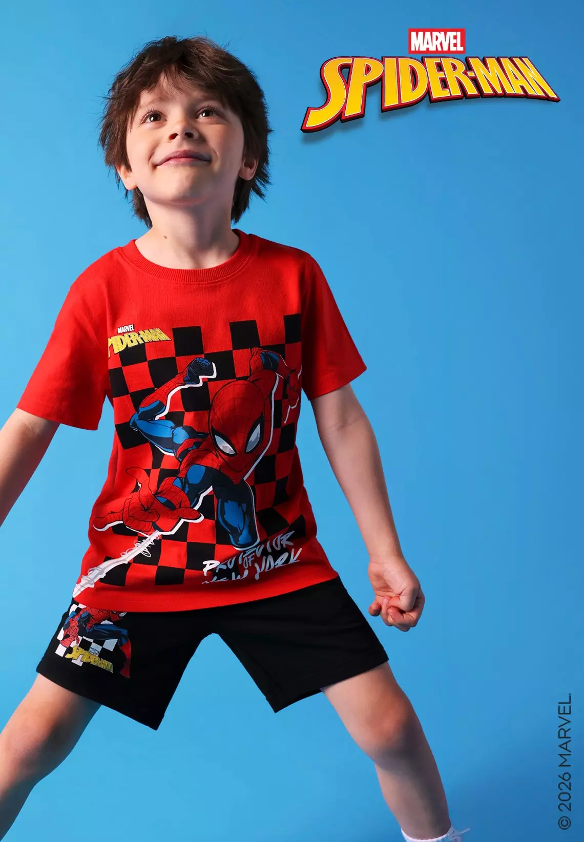 Niño mirando hacia arriba con conjunto Pepco de camiseta roja y pantalón corto negro de Marvel Spiderman.