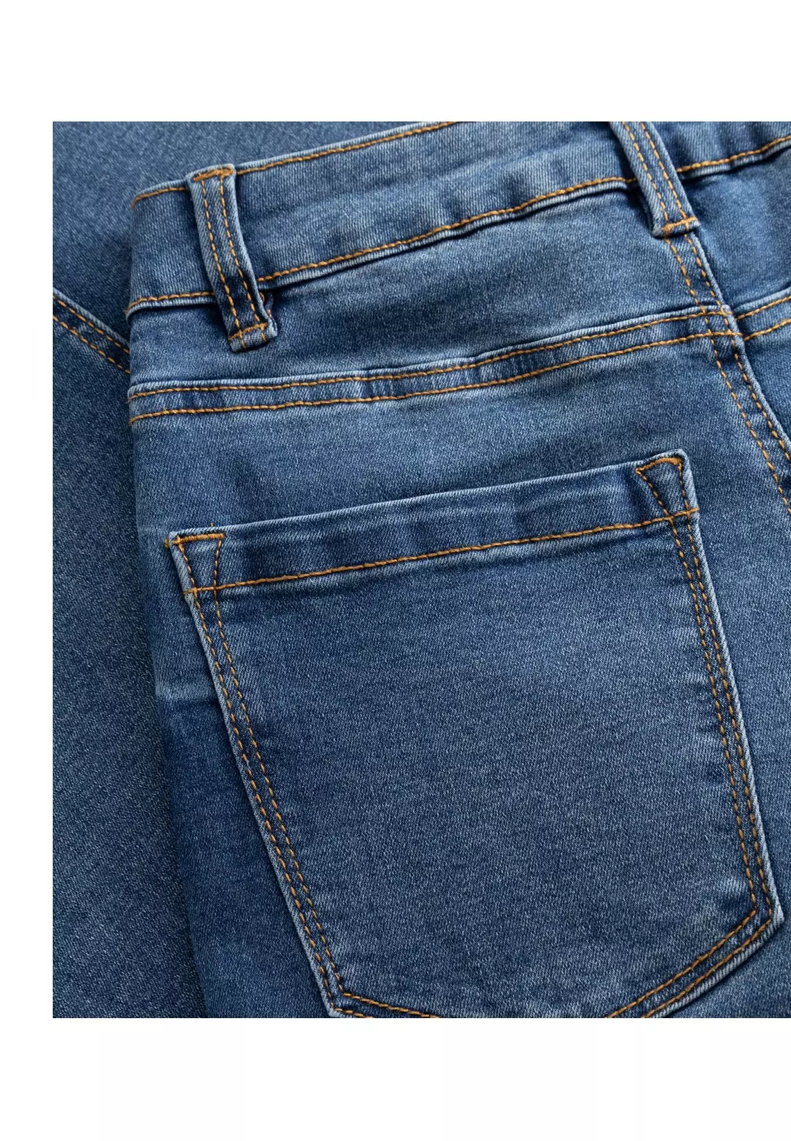 Pepco women's blue denim jeggings with elasticated waistband worn with white trainers.