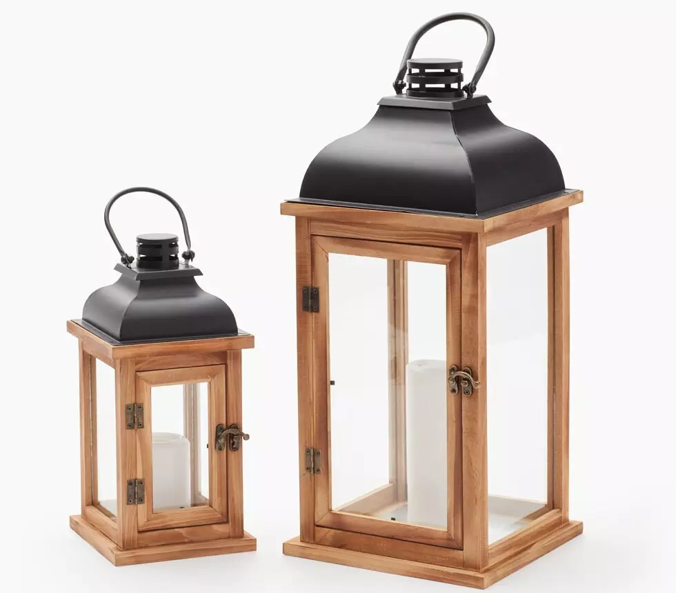 Dwa drewniane lampiony Pepco z czarnymi metalowymi daszkami, mniejszy i większy, ze świecami w środku.