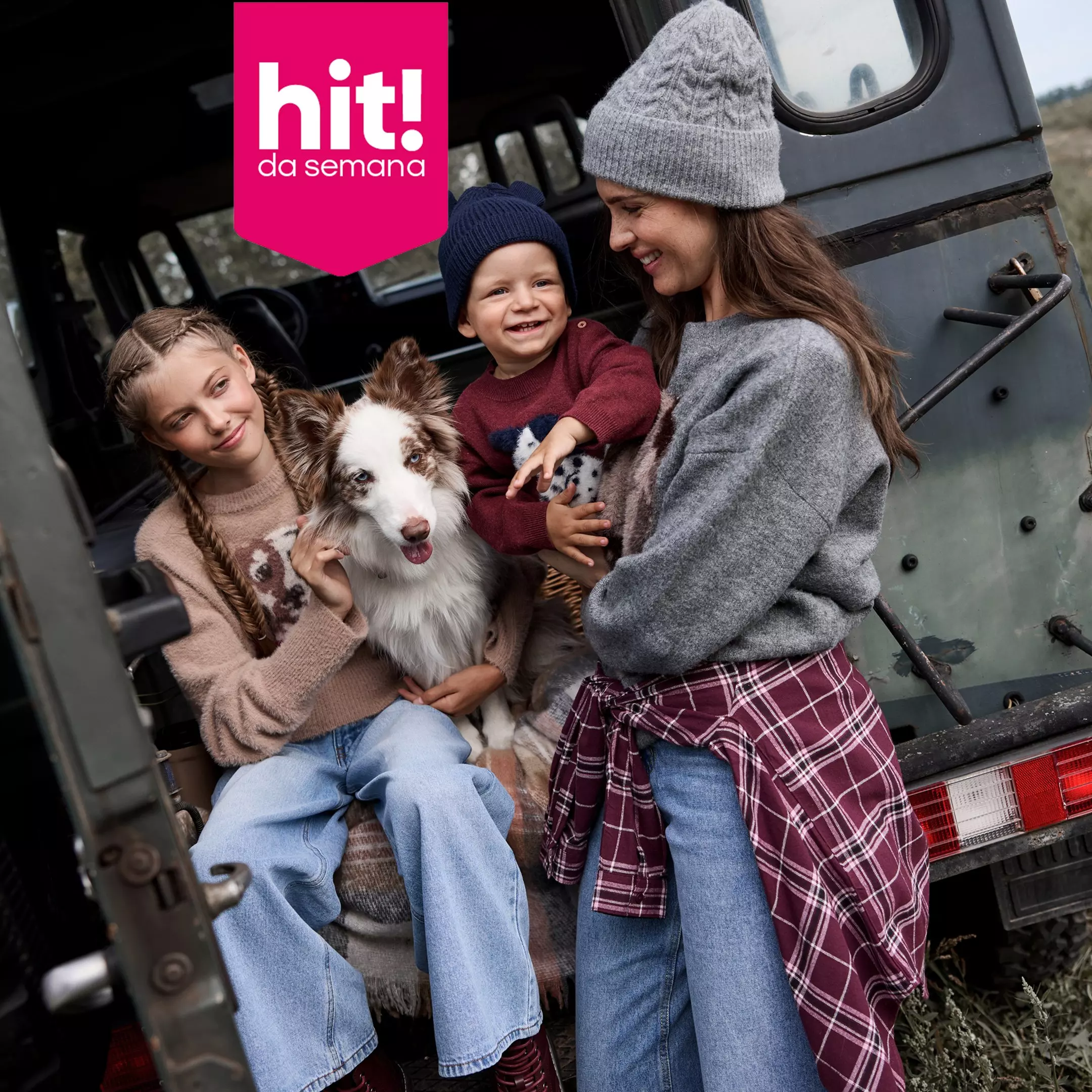 Família Pepco feliz sentada na bagageira de um carro com o seu cão, usando malhas e gorros de inverno.