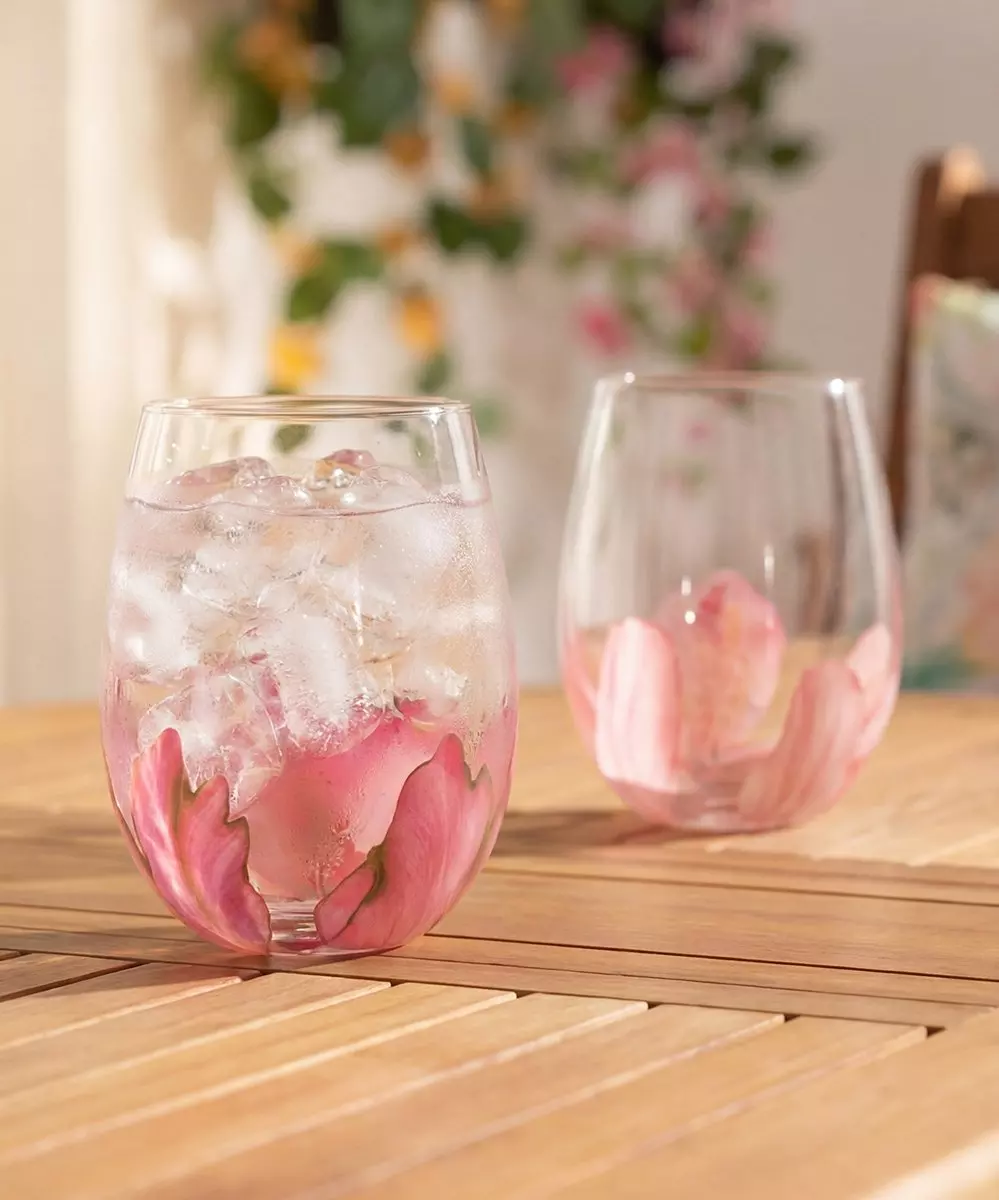 Pepco stemless wine glasses with pink floral design filled with ice and drinks on wooden table.