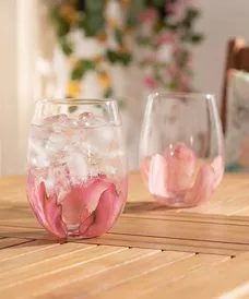 Pepco stemless wine glasses with pink floral design filled with ice and drinks on wooden table.
