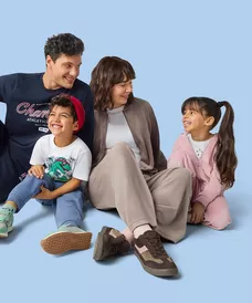 Family sitting together wearing casual clothing including Champion t-shirt, dinosaur print shirt, and pink jacket.