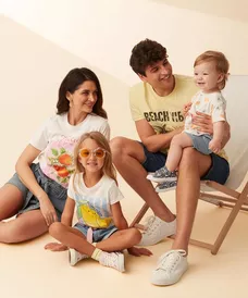 Rodzina w letnich t-shirtach z nadrukami owocowymi i szortach dżinsowych, pozująca razem.