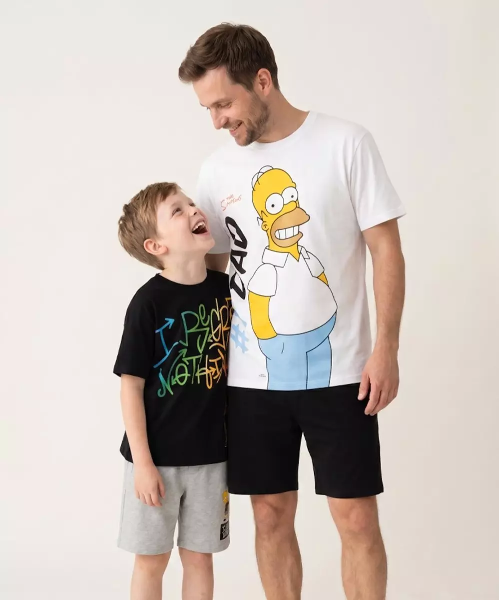 Muž a chlapec v tričkách Pepco se Simpsonovými postavami se na sebe usmívají.