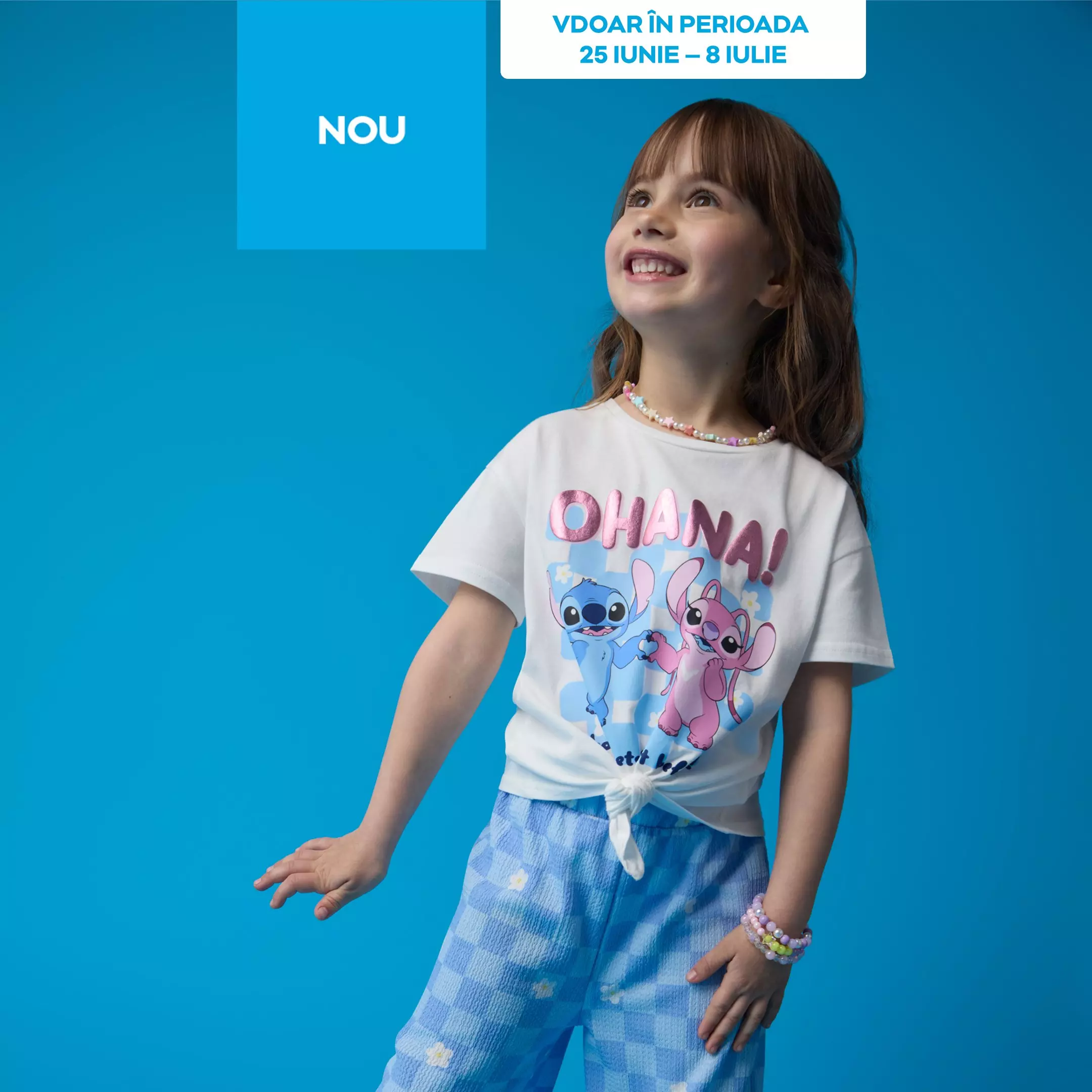 Fată zâmbitoare purtând tricou alb Pepco cu personaje Disney Stitch și pantaloni albaștri cu buline.
