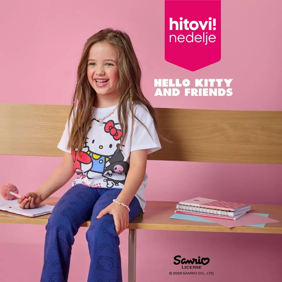 Devojčica sedi na stolu u Pepco Hello Kitty majici i plavim pantalonama sa školskim priborom.