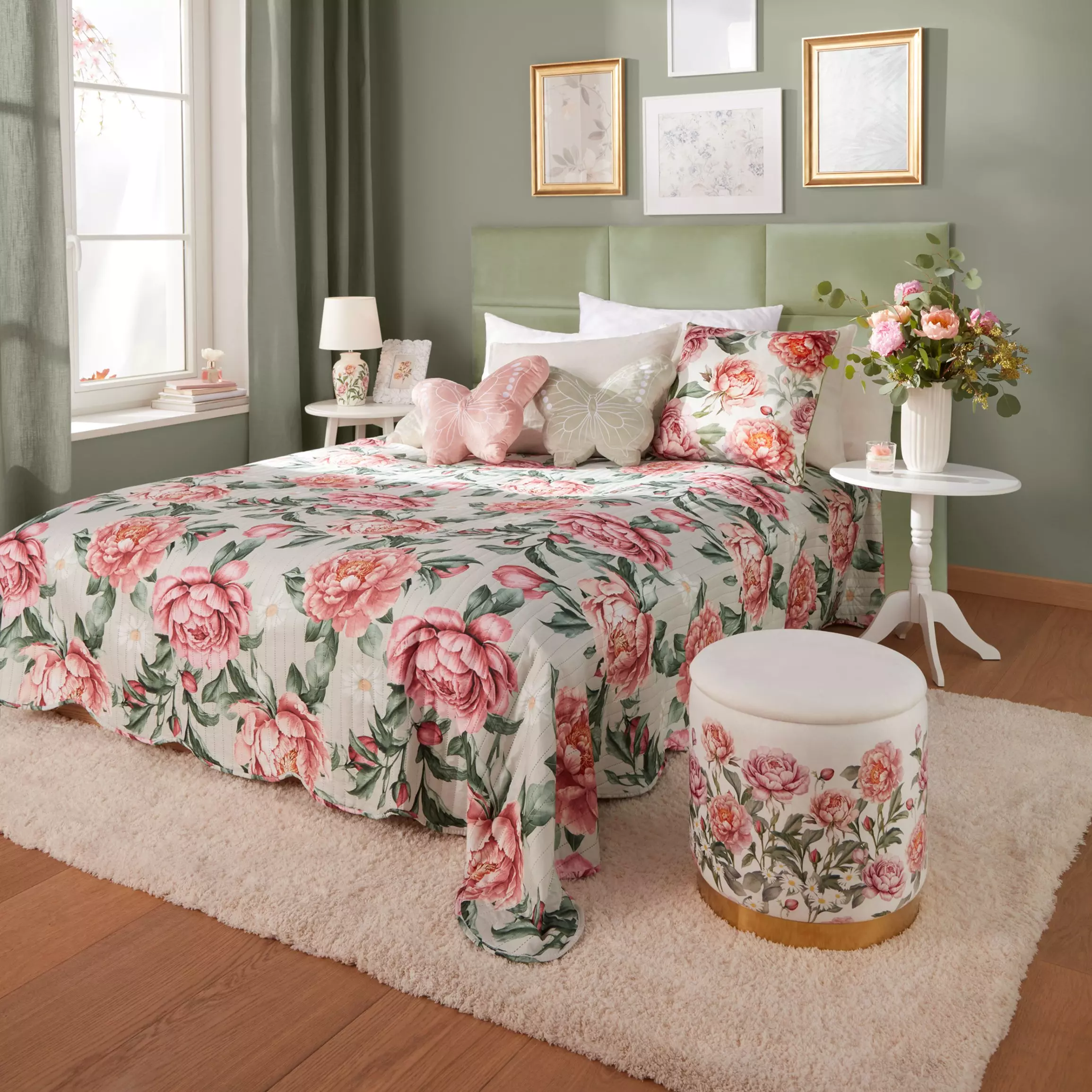 Pepco bedroom set featuring floral bedding, matching cushions, and ottoman stool with pink peony pattern in a sage green room.