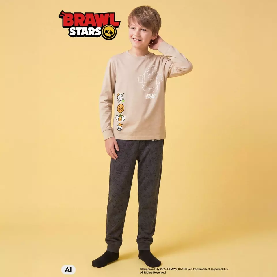 Pepco pijama pentru băieți Brawl Stars, bluză bej și pantaloni gri cu imprimeu, purtată de un copil.