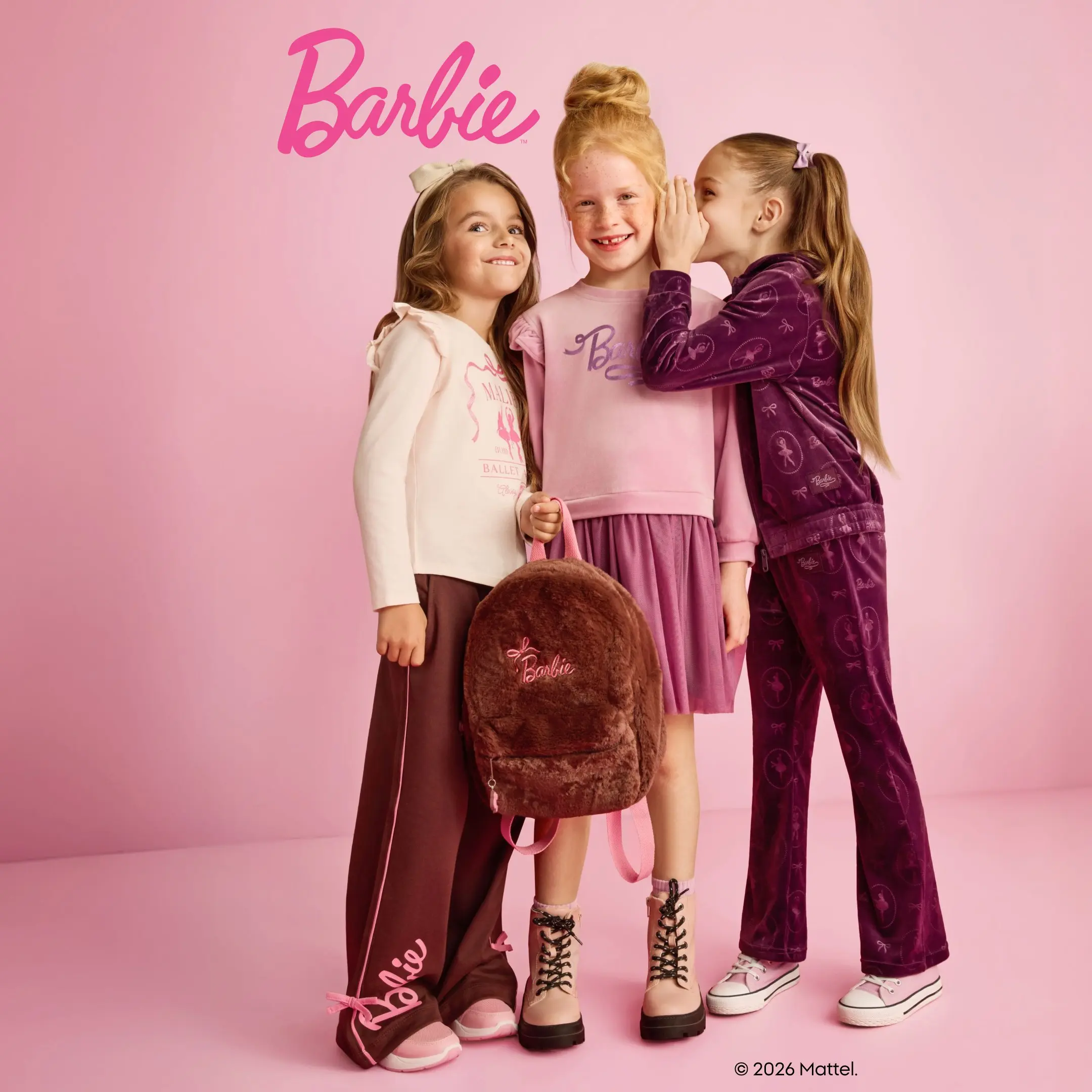Pepco: trzy dziewczynki w ubraniach Barbie, jedna szepcze do ucha drugiej, obok plecak z napisem Barbie.