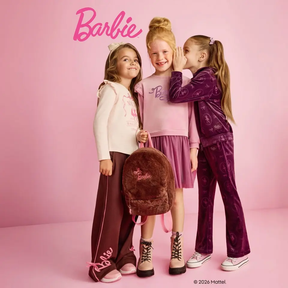 Pepco: trzy dziewczynki w ubraniach Barbie, jedna szepcze do ucha drugiej, obok plecak z napisem Barbie.
