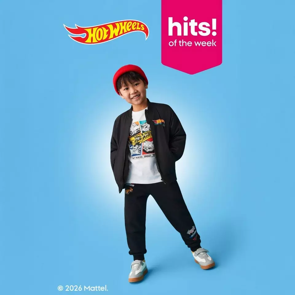 Child wearing Hot Wheels branded outfit with red beanie, black jacket and pants against blue background. "Hits of the week" banner shown.
