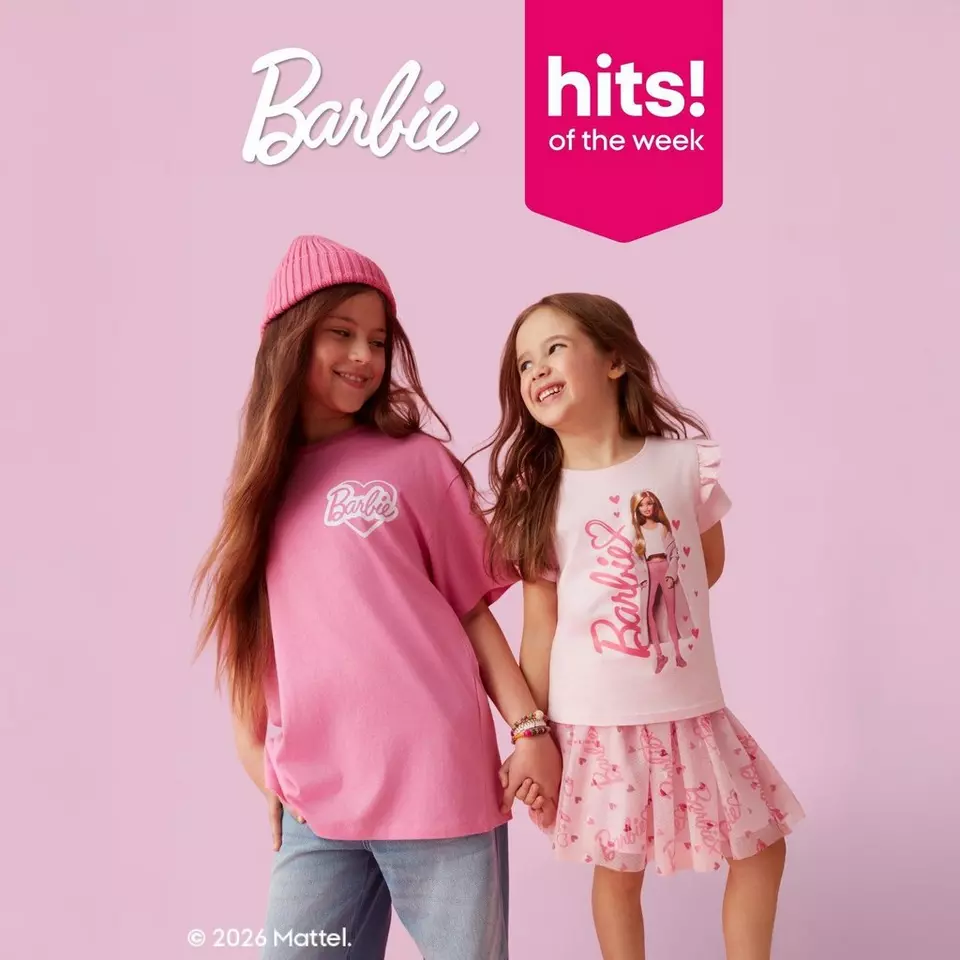 Two children wearing Barbie branded clothing - pink t-shirt and pink beanie, and white t-shirt with pink skirt - holding hands against pink background.