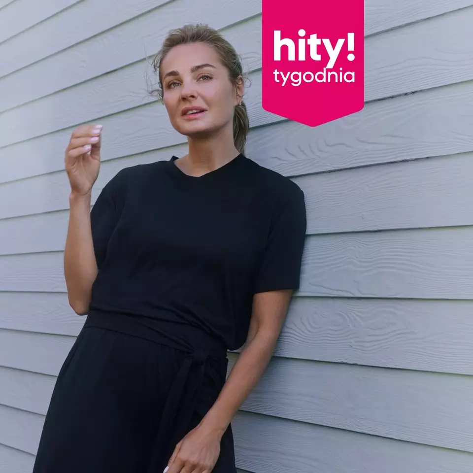 Kobieta w czarnym t-shircie i spodniach, logo "hity! tygodnia" w rogu obrazu.
