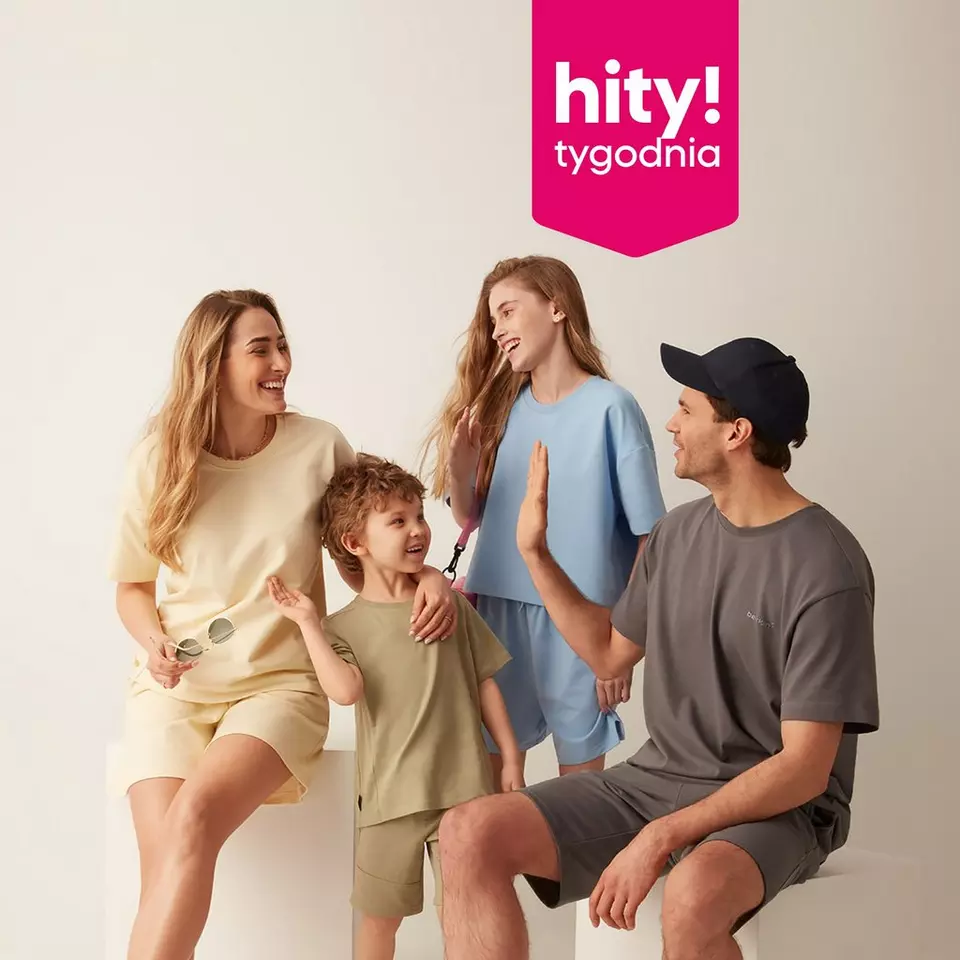 Uśmiechnięta rodzina w pasujących do siebie strojach pod różowym banerem z napisem "hity! tygodnia".