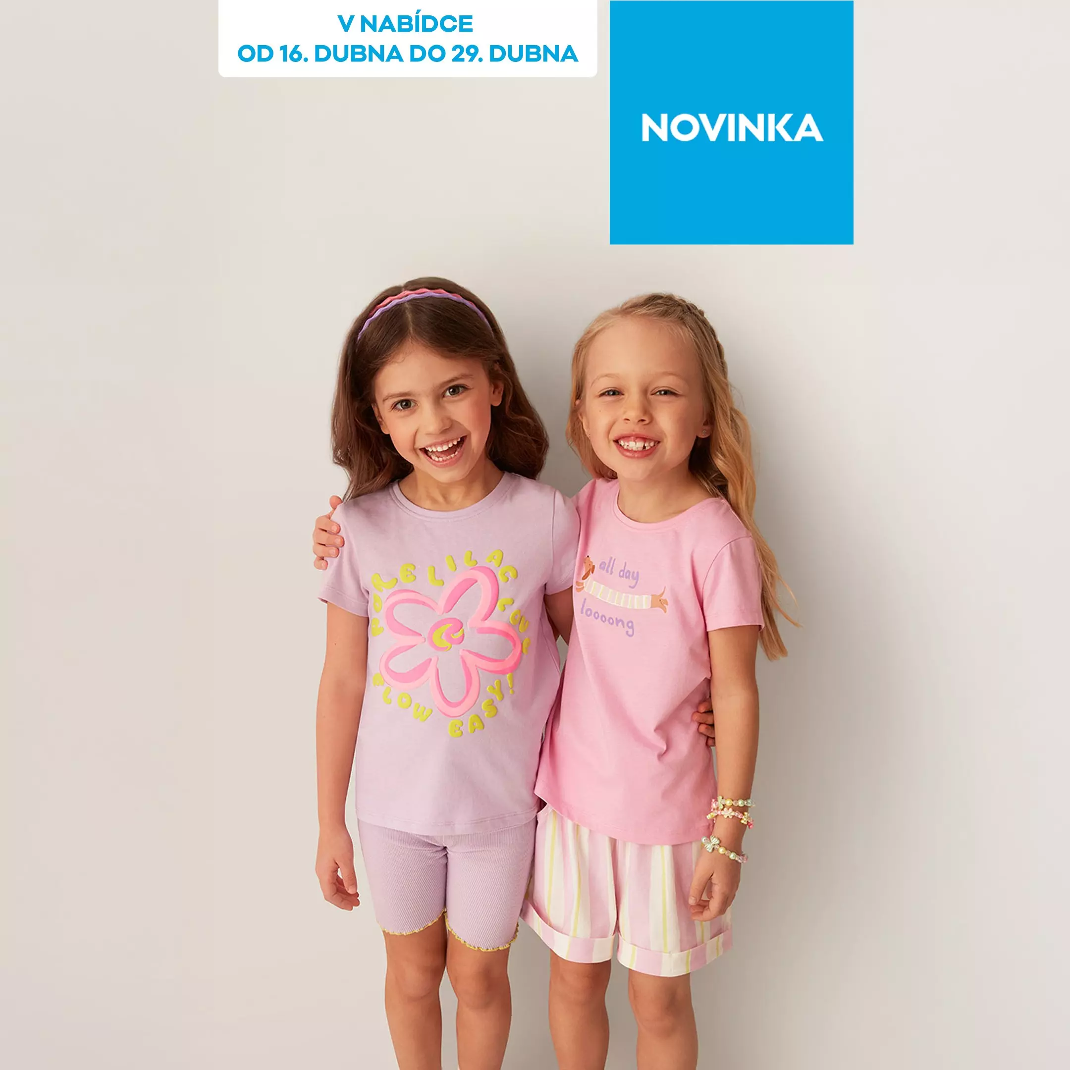 Dvě usmívající se dívky v růžových pyžamech s krátkými rukávy a šortkami.