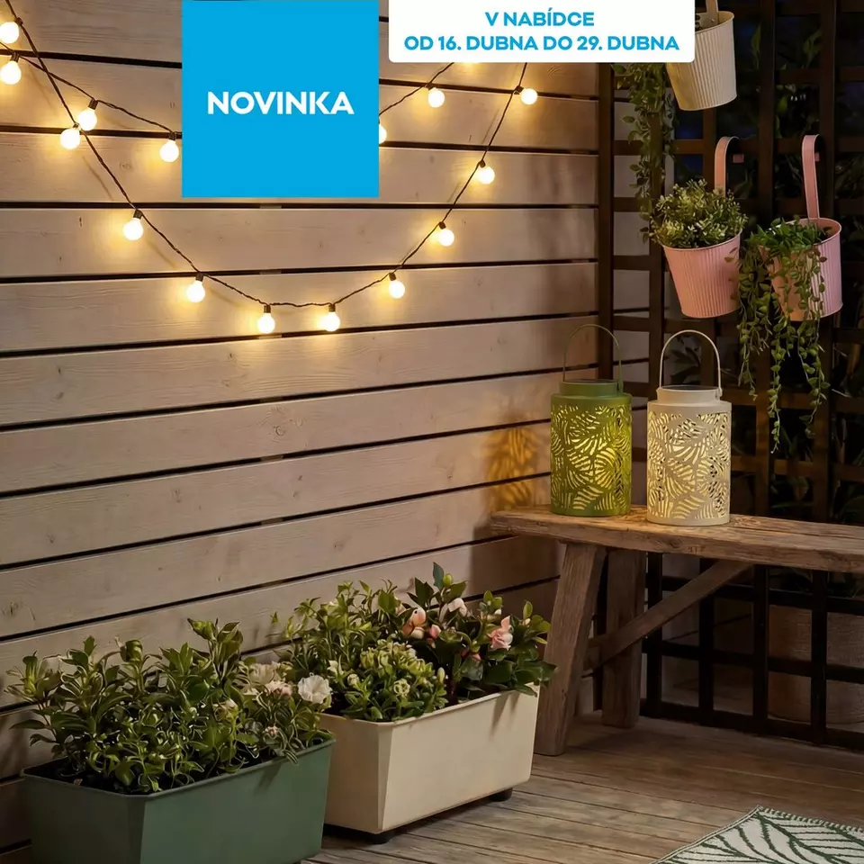 Venkovní dekorace se světelnými řetězy, dekorativními lucernami a květinovými truhlíky na dřevěné terase.