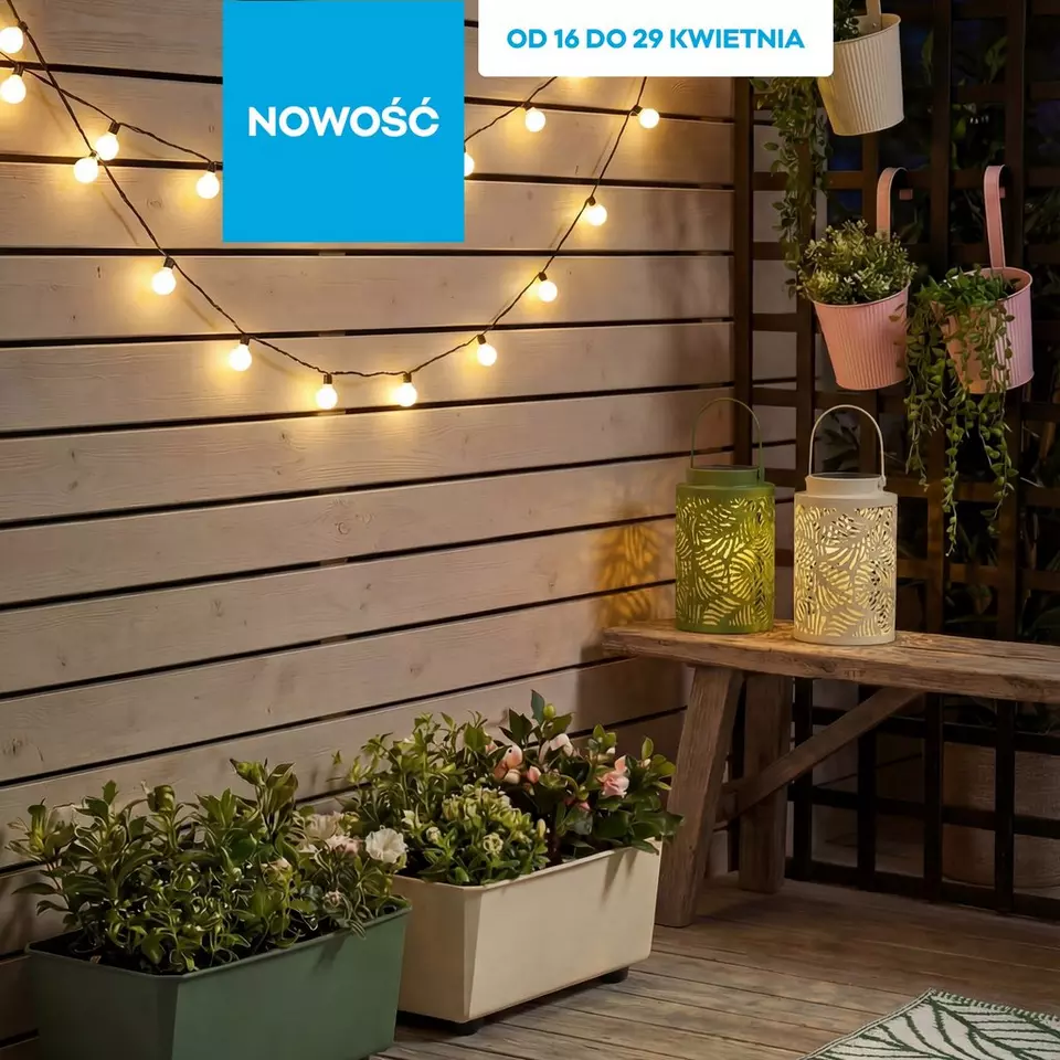 Dekoracyjne lampki ogrodowe i latarnie LED z roślinami na drewnianym tarasie.