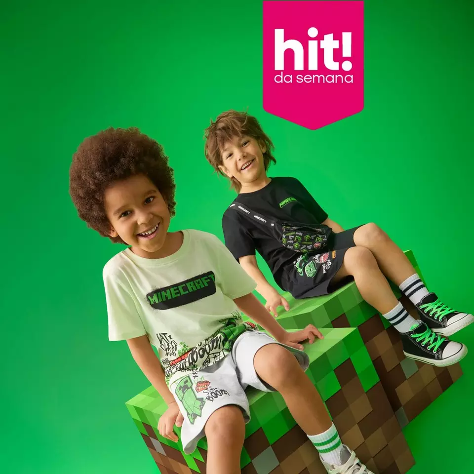 Dois rapazes sorridentes usando roupa com tema Minecraft, sentados em blocos decorativos do jogo.