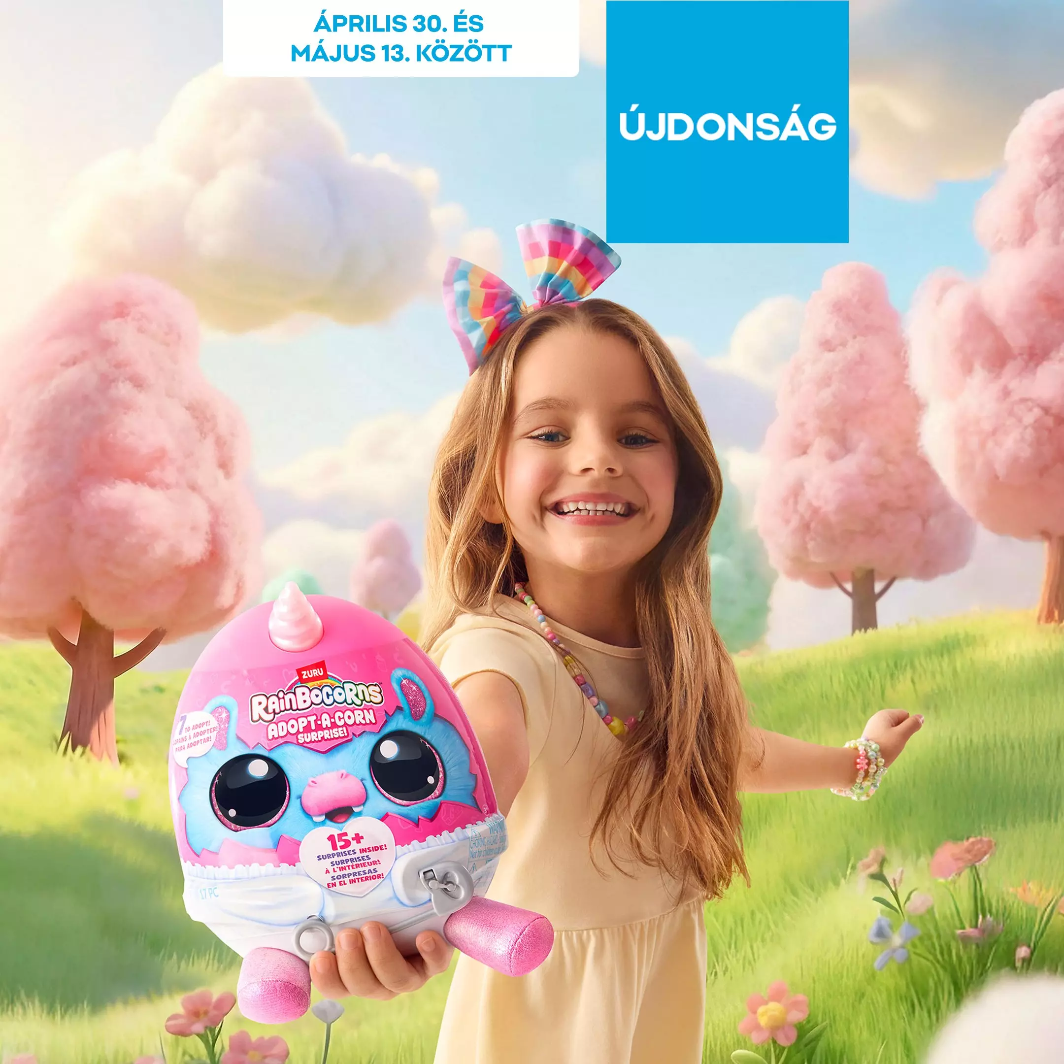 Mosolygó kislány színes hajpánttal Rainbocorns játékot tart, fantáziadús rózsaszín felhős háttér előtt.