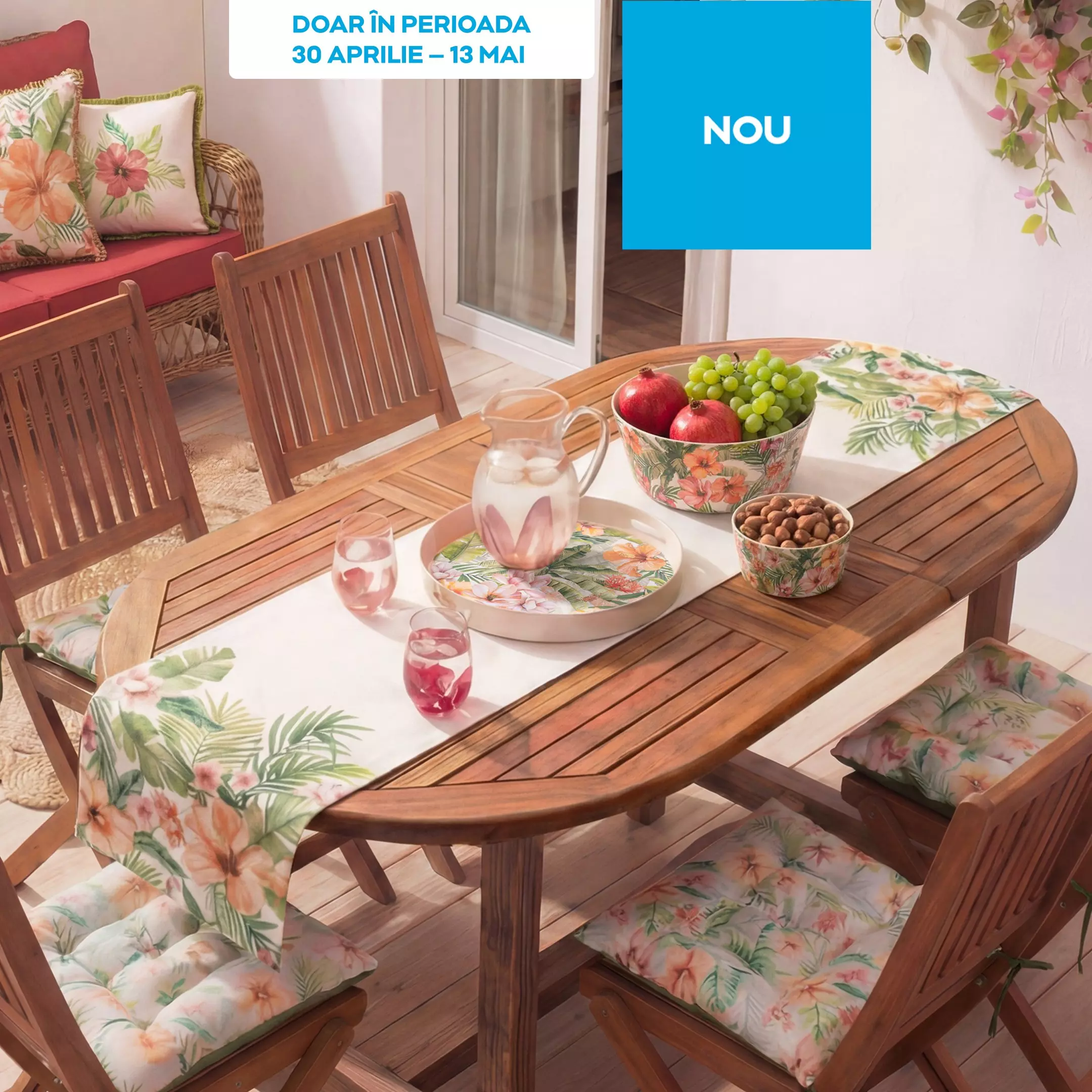 Set de mobilier de grădină din lemn cu masă ovală și scaune, decorat cu accesorii florale tropicale.