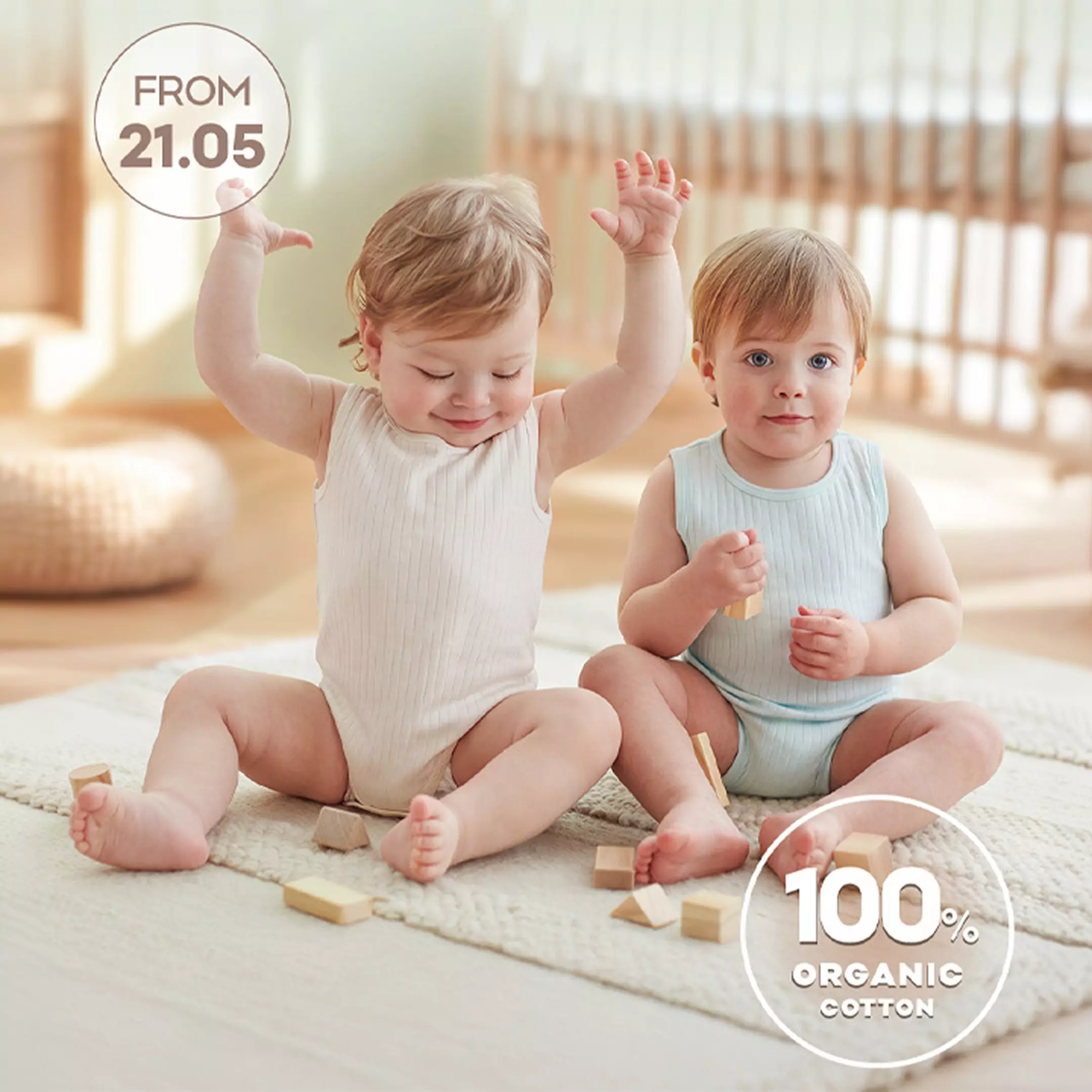 Two toddlers in ribbed cotton vests playing with wooden blocks on a rug, FROM 21.05, 100% ORGANIC COTTON.