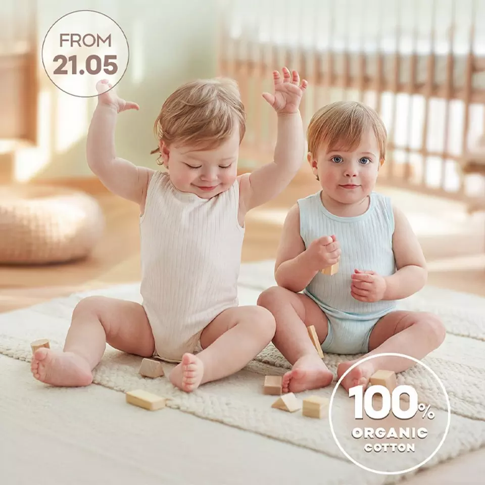 Two toddlers in ribbed cotton vests playing with wooden blocks on a rug, FROM 21.05, 100% ORGANIC COTTON.