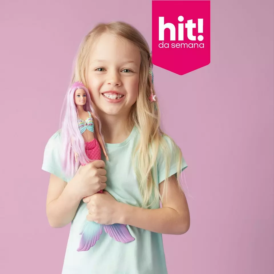 Menina sorridente a segurar uma boneca sereia com cabelo rosa, promoção hit da semana Pepco.