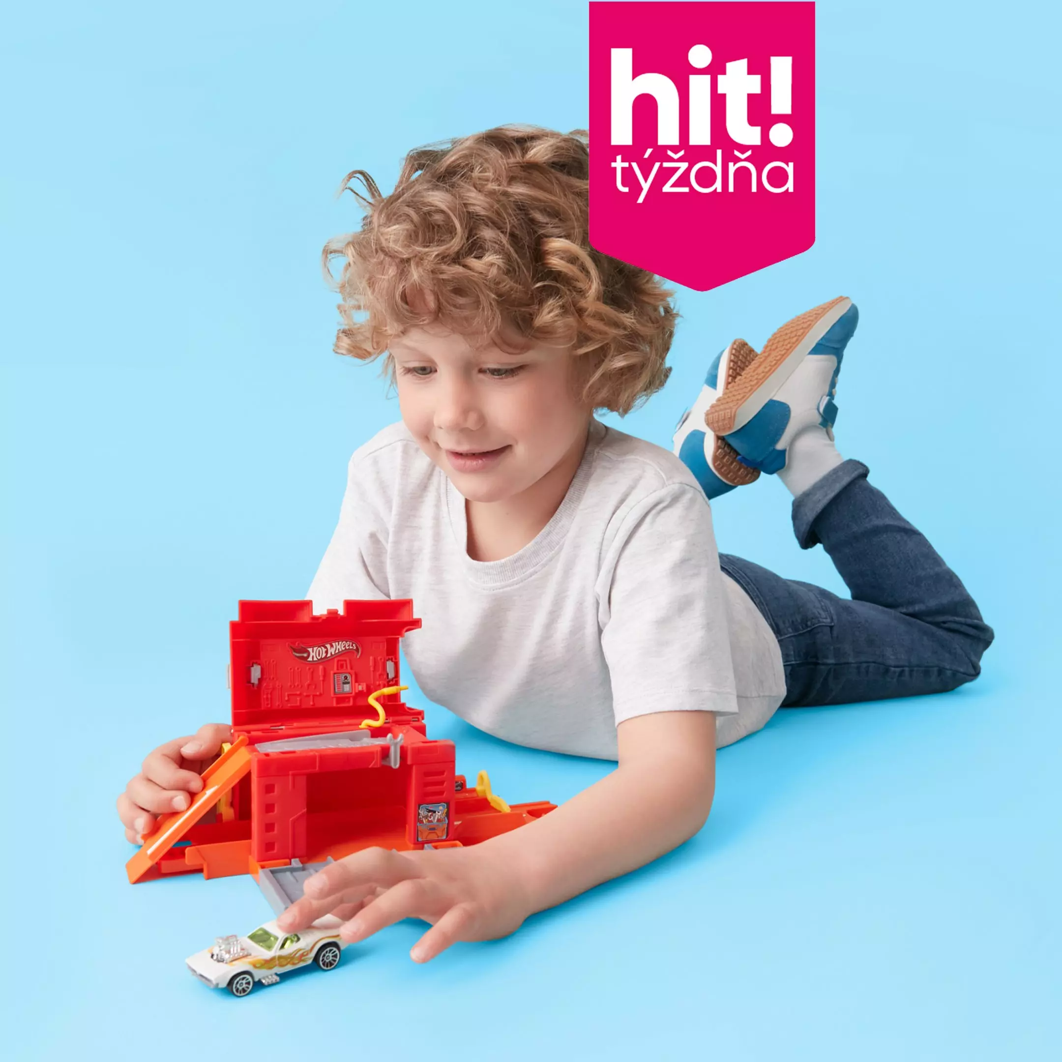 Chlapec si hrá s červenou garážou Hot Wheels a autíčkom v ponuke Pepco hit! týždňa.