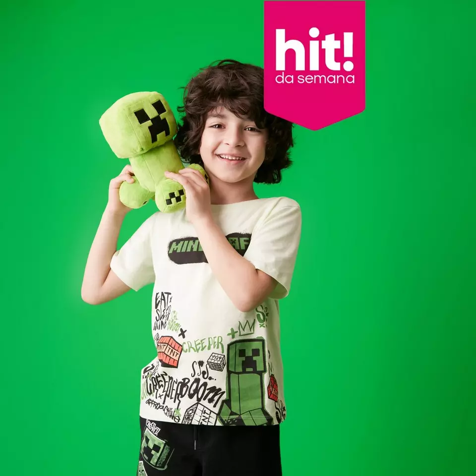 Criança sorridente segura peluche Minecraft Creeper, veste t-shirt temática Minecraft da Pepco.