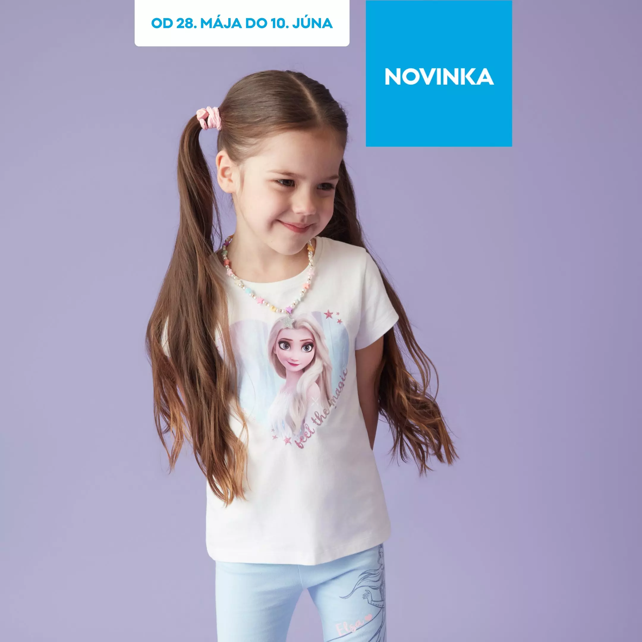 Dievča v bielom Pepco tričku s Disney motívom Frozen a s farebnými gumičkami vo vlasoch sa usmieva.