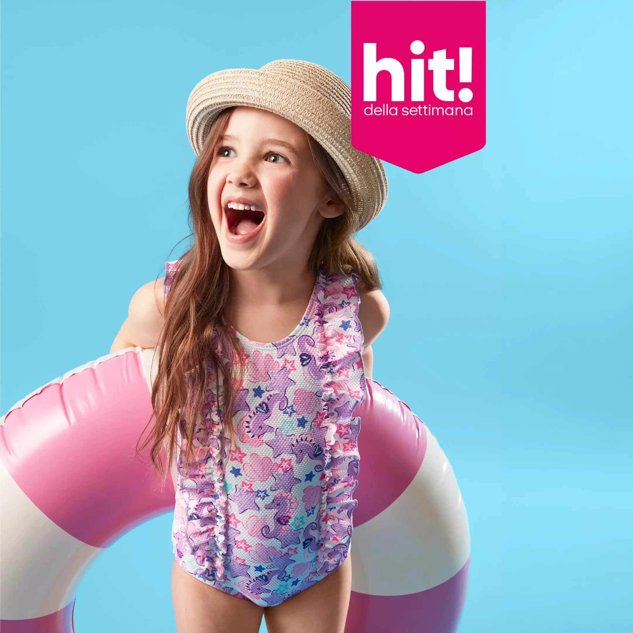 Bambina Pepco indossa costume da bagno floreale e cappello di paglia con braccioli gonfiabili rosa.
