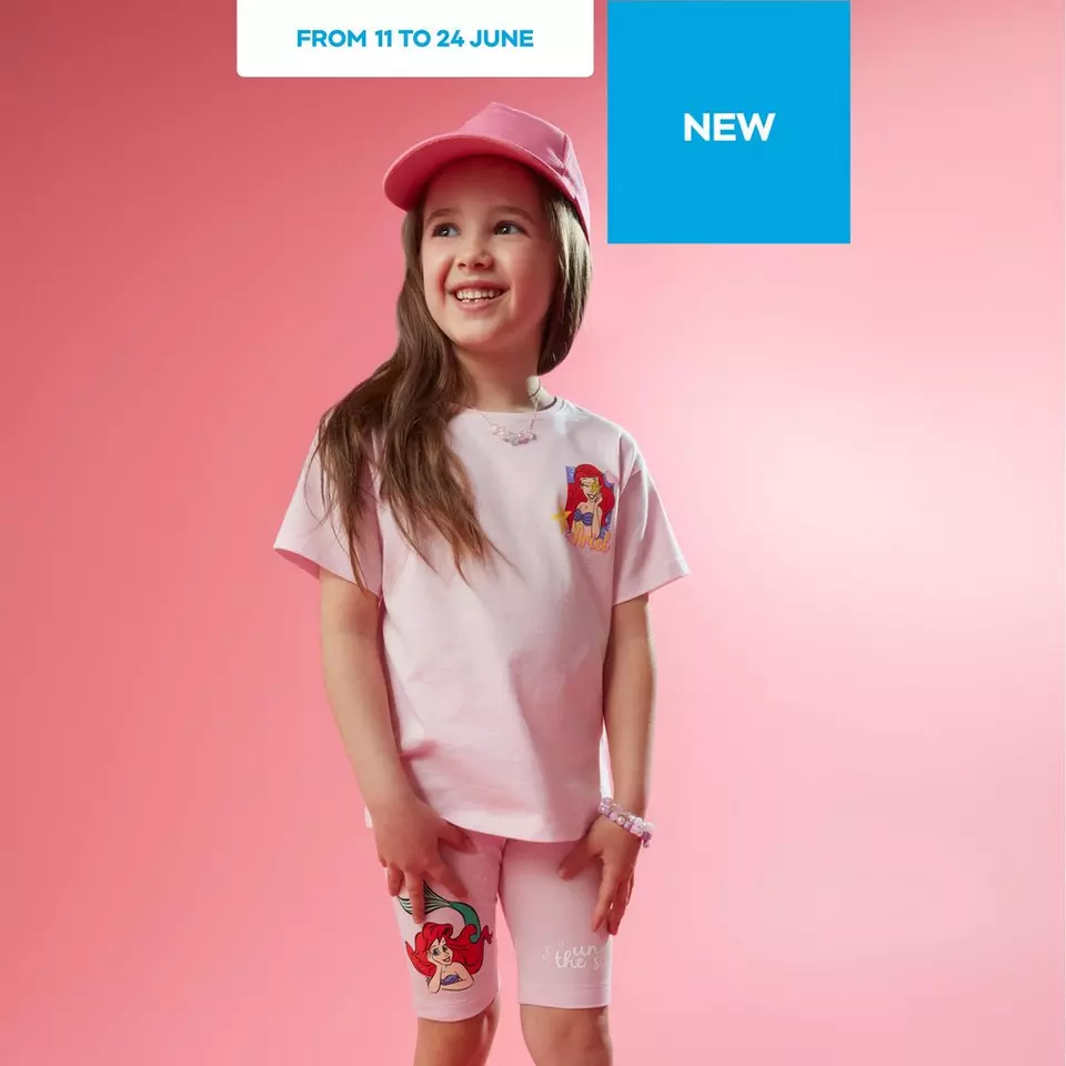 Pepco girl wearing pink cap with Disney Ariel character t-shirt and matching shorts smiling upwards.